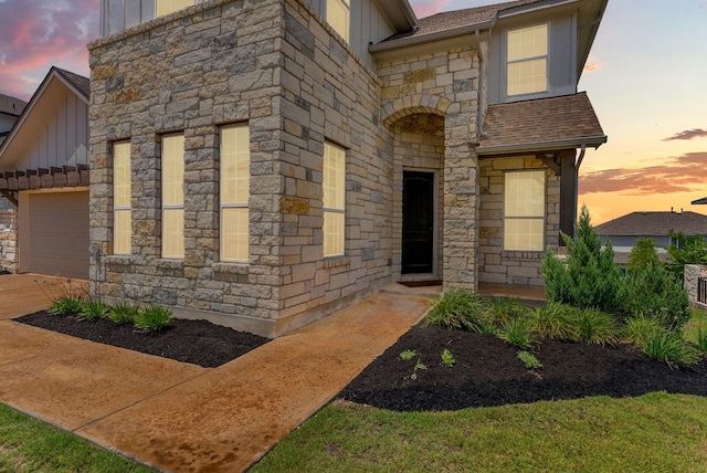 604 Buena Onda Way, Lakeway, TX 78738 - view of front of house with board and batten siding, stone siding, a shingled roof, an attached garage, and driveway