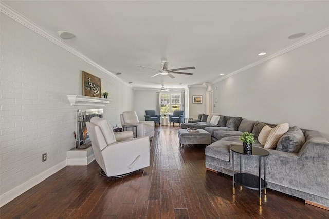 17700 N Rim Dr, Leander, TX 78641 - living area with wood-type flooring, ceiling fan, crown molding, a warm lit fireplace, and brick wall