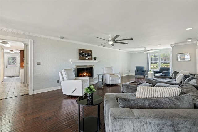 17700 N Rim Dr, Leander, TX 78641 - living area featuring ornamental molding, a ceiling fan, dark wood-style floors, a glass covered fireplace, and brick wall