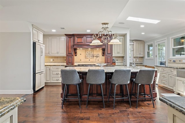 17700 N Rim Dr, Leander, TX 78641 - kitchen with paneled built in refrigerator, a skylight, tasteful backsplash, dark wood-style flooring, and recessed lighting