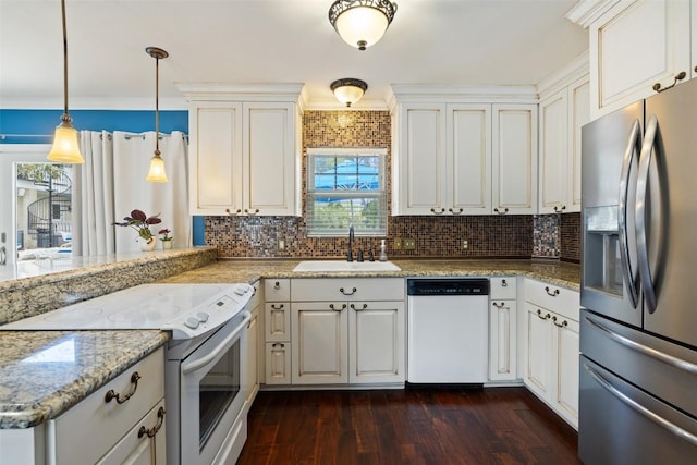 kitchen featuring white appliances, a sink, healthy amount of natural light, and tasteful backsplash