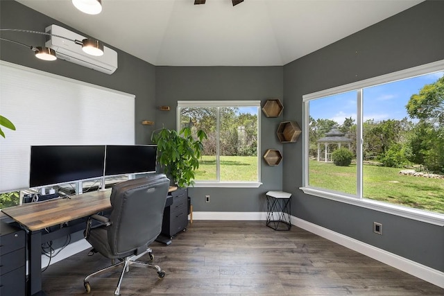 office space featuring a wall mounted AC, lofted ceiling, wood finished floors, baseboards, and ceiling fan