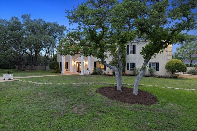 view of front facade featuring a front yard and brick siding