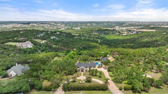 aerial view of property and surrounding area featuring a forest