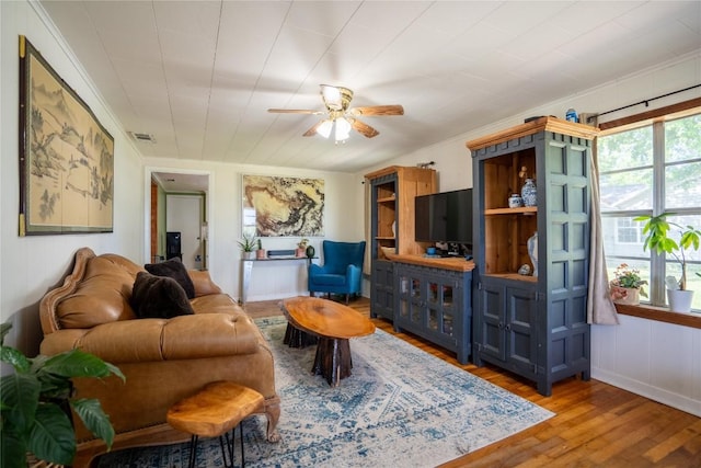 1705 Old Thorndale Rd, Taylor, TX 76574 - living room featuring a ceiling fan, wood finished floors, and ornamental molding