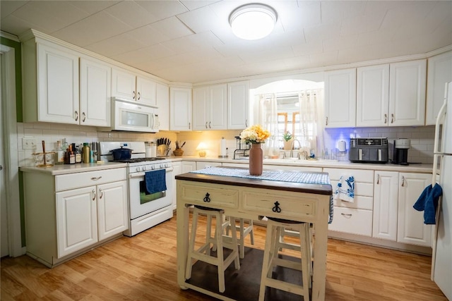 1705 Old Thorndale Rd, Taylor, TX 76574 - kitchen with white appliances, tasteful backsplash, and white cabinetry