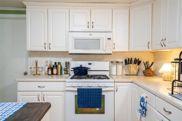 1705 Old Thorndale Rd, Taylor, TX 76574 - kitchen featuring white appliances, decorative backsplash, white cabinets, and light countertops