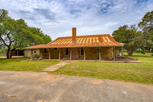624 N US Highway 281, Johnson City, TX 78636 - back of property with a chimney, a porch, a lawn, and stone siding