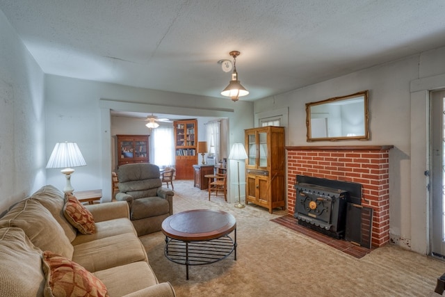624 N US Highway 281, Johnson City, TX 78636 - carpeted living room featuring a wood stove, ceiling fan, and a textured ceiling