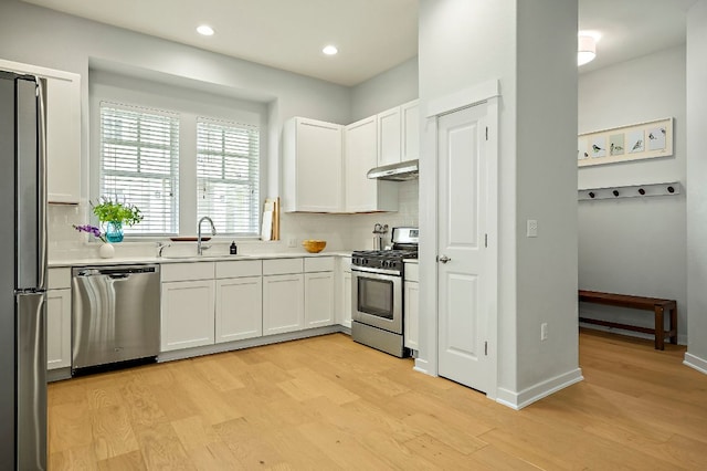 4003 Vaughan St, Austin, TX 78723 - kitchen with stainless steel appliances, under cabinet range hood, light wood-style floors, decorative backsplash, and recessed lighting