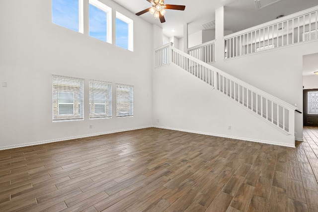 1100 Whipple Tree Trl, Georgetown, TX 78626 - unfurnished living room with a high ceiling, a ceiling fan, plenty of natural light, stairs, and wood finished floors