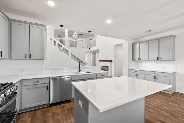 1100 Whipple Tree Trl, Georgetown, TX 78626 - kitchen with dishwasher, gray cabinetry, a sink, a ceiling fan, and a peninsula