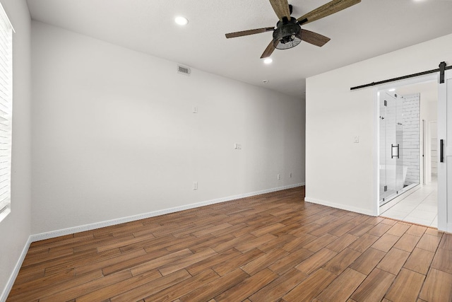 1100 Whipple Tree Trl, Georgetown, TX 78626 - spare room with a barn door, a ceiling fan, wood finished floors, recessed lighting, and baseboards