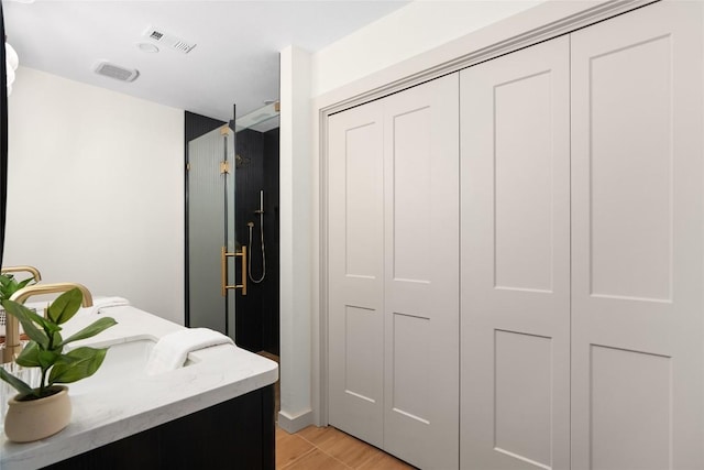2209 Forest Bend Dr, Austin, TX 78704 - bathroom featuring a closet, a shower stall, wood finished floors, and double vanity