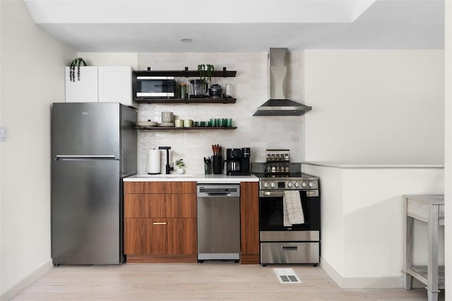 2209 Forest Bend Dr, Austin, TX 78704 - kitchen with appliances with stainless steel finishes, wall chimney exhaust hood, light wood-type flooring, backsplash, and light countertops