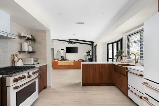 2209 Forest Bend Dr, Austin, TX 78704 - kitchen featuring white appliances, wall chimney exhaust hood, light countertops, decorative backsplash, and a ceiling fan