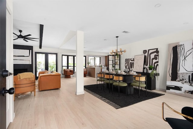 2209 Forest Bend Dr, Austin, TX 78704 - dining area featuring wood finished floors, french doors, a ceiling fan, and a chandelier