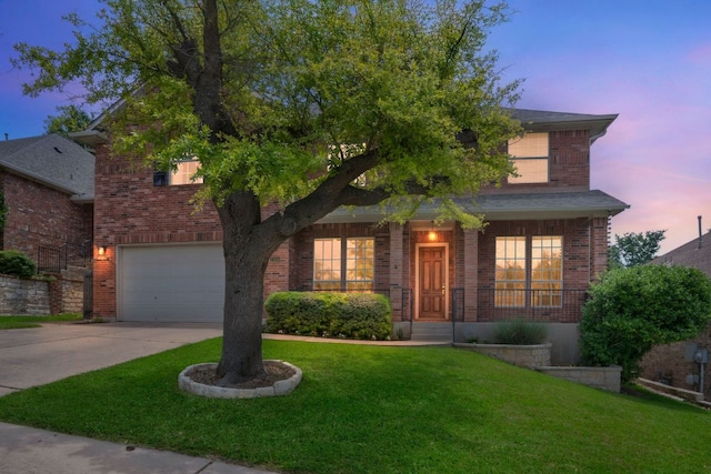 traditional home featuring an attached garage, driveway, a lawn, and brick siding