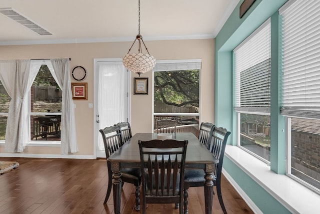 dining room with hardwood / wood-style floors, plenty of natural light, crown molding, and baseboards
