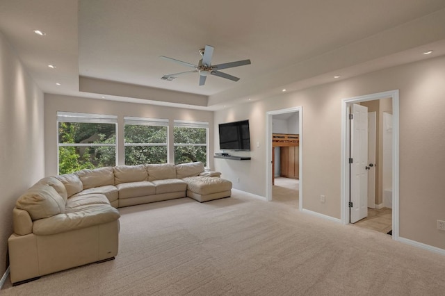 living room with a ceiling fan, light carpet, a raised ceiling, baseboards, and recessed lighting
