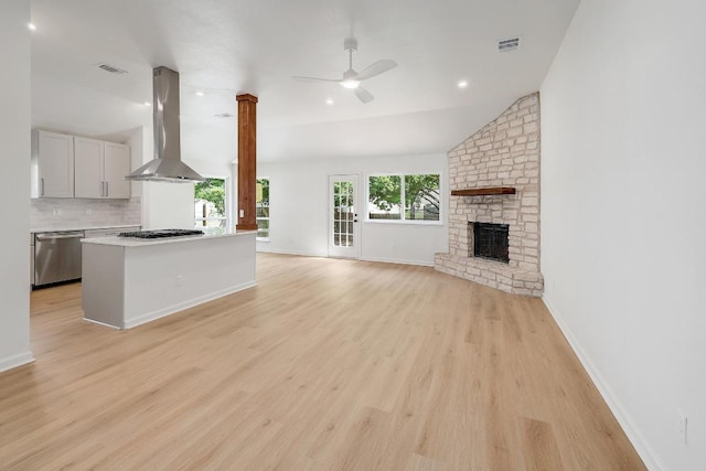 2602 Water Well Ln, Austin, TX 78728 - unfurnished living room featuring lofted ceiling, a ceiling fan, light wood-style flooring, a brick fireplace, and baseboards