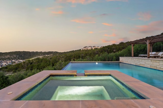 outdoor pool with a pergola and an in-ground hot tub