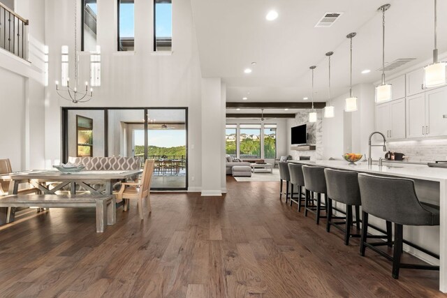 dining area featuring a towering ceiling, dark wood-type flooring, and recessed lighting