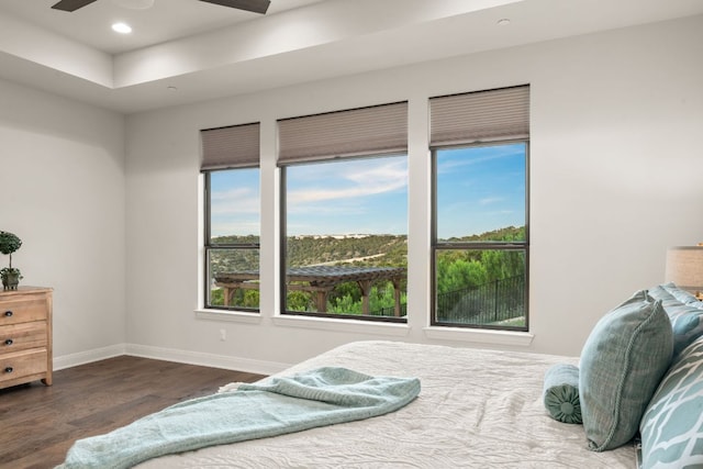 bedroom with multiple windows, wood finished floors, baseboards, and recessed lighting