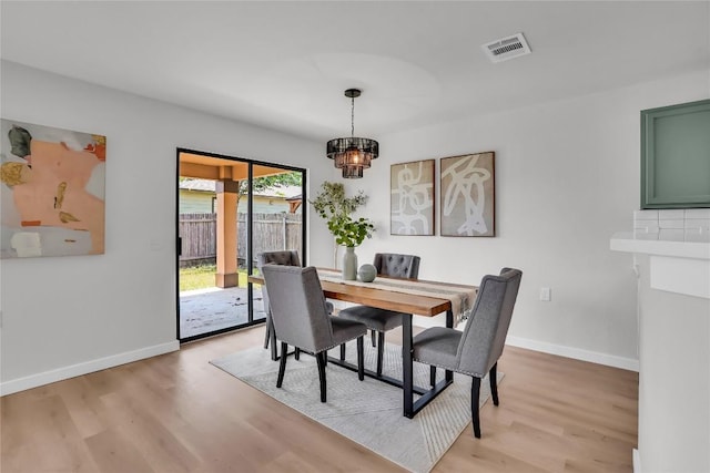 8921 Norwich Castle, Austin, TX 78747 - dining area featuring light wood-style flooring, a chandelier, and baseboards