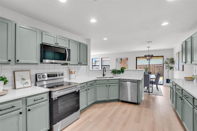 8921 Norwich Castle, Austin, TX 78747 - kitchen featuring appliances with stainless steel finishes, a sink, a peninsula, healthy amount of natural light, and recessed lighting