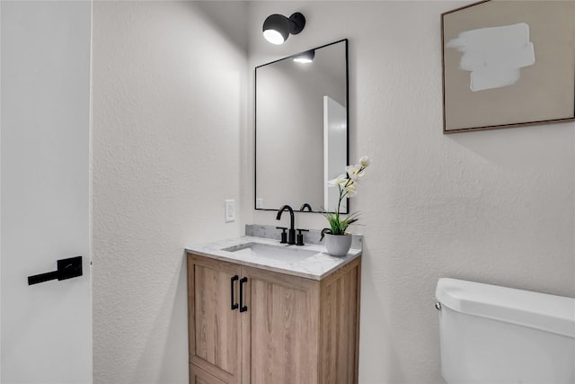 8921 Norwich Castle, Austin, TX 78747 - half bathroom with toilet, vanity, and a textured wall