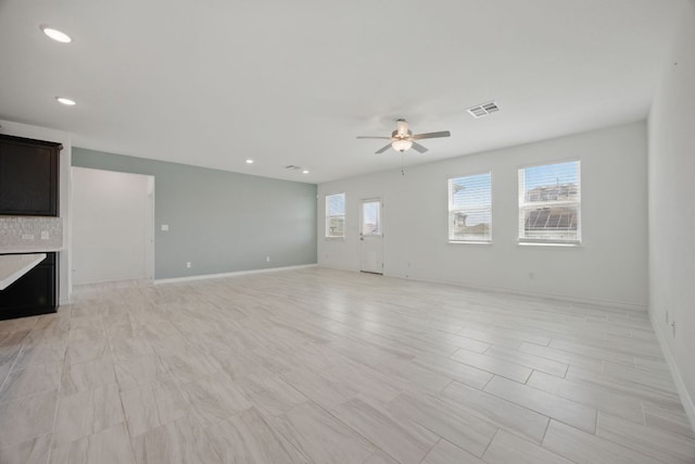 unfurnished living room featuring a ceiling fan, recessed lighting, and baseboards
