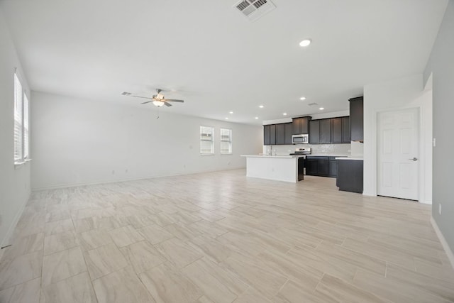unfurnished living room with a ceiling fan, recessed lighting, and baseboards