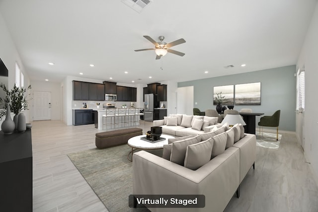 living area with ceiling fan, recessed lighting, and baseboards