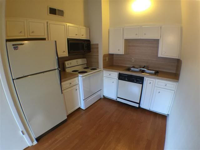 2404 Longview St Unit 205, Austin, TX 78705 - kitchen featuring white appliances, a sink, white cabinets, backsplash, and dark wood-style flooring
