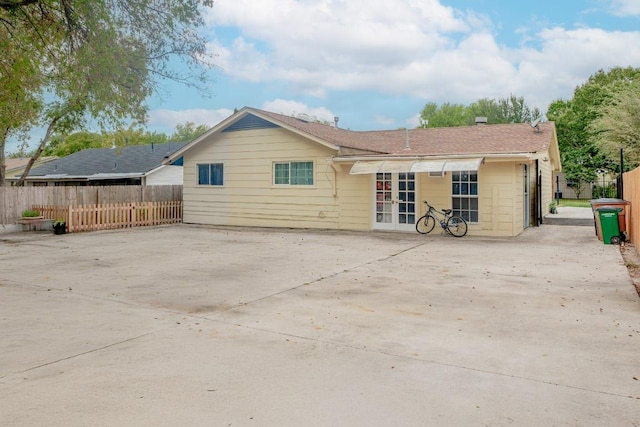 9801 Oriole Dr, Austin, TX 78753 - back of property featuring french doors, a patio area, and roof with shingles