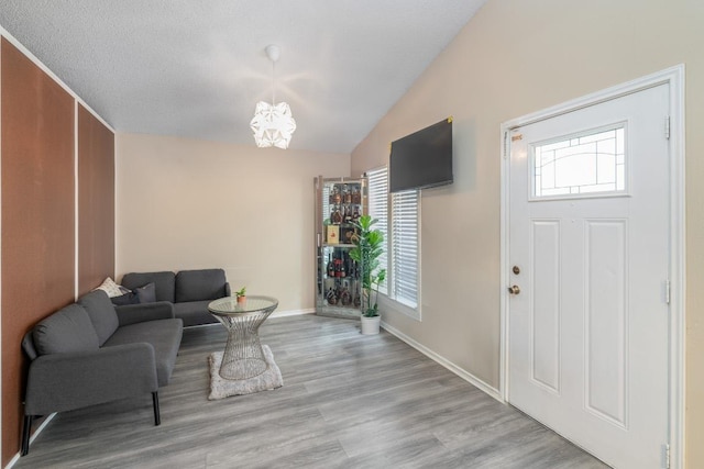9801 Oriole Dr, Austin, TX 78753 - foyer with wood finished floors, lofted ceiling, baseboards, and a chandelier