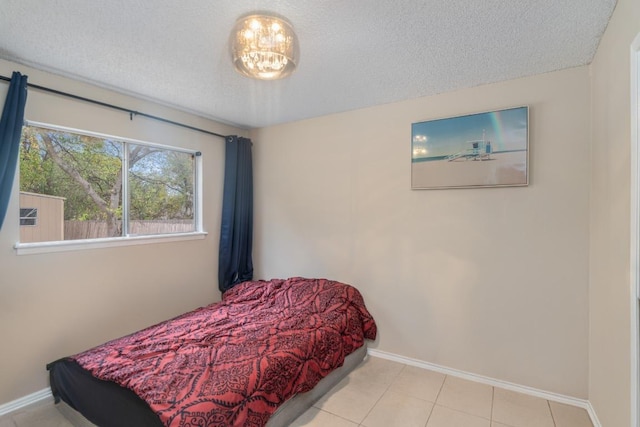 9801 Oriole Dr, Austin, TX 78753 - tiled bedroom with baseboards and a textured ceiling