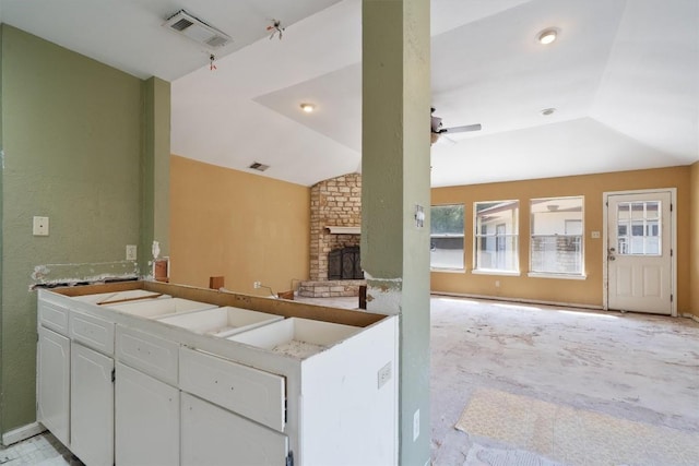 7008 Beckett Rd, Austin, TX 78749 - kitchen with open floor plan, white cabinets, a brick fireplace, a peninsula, and lofted ceiling