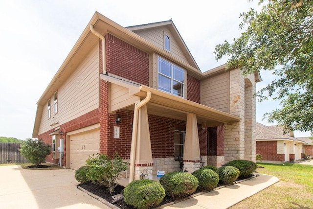 18701 Jana Patrice Dr, Pflugerville, TX 78660 - view of home's exterior with an attached garage, brick siding, concrete driveway, stone siding, and covered porch