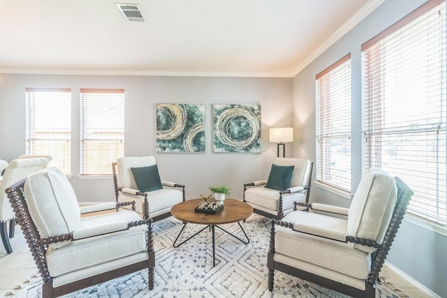 living area featuring baseboards, crown molding, and healthy amount of natural light