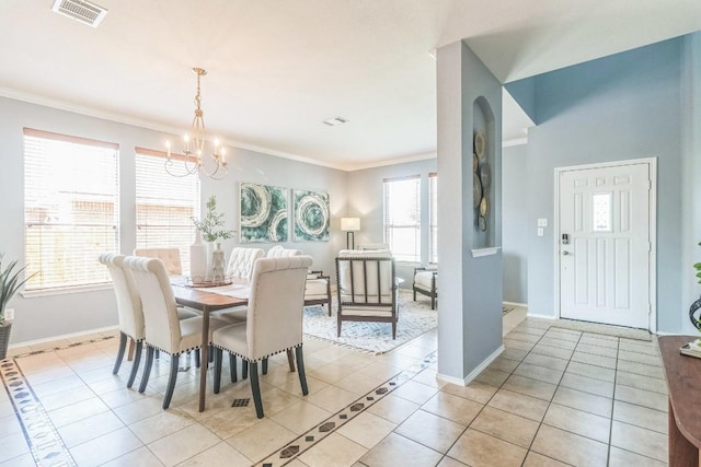 dining room featuring a chandelier, light tile patterned flooring, baseboards, and crown molding