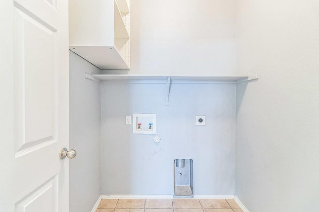 laundry area with hookup for a washing machine, electric dryer hookup, gas dryer hookup, light tile patterned floors, and baseboards