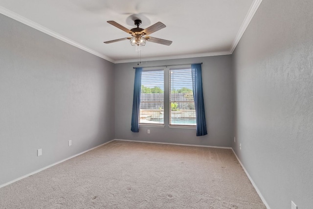 empty room featuring ornamental molding, a ceiling fan, carpet flooring, and baseboards