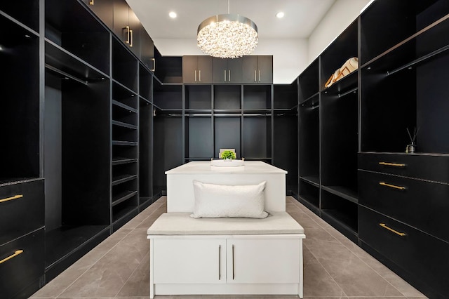 spacious closet featuring a chandelier and light tile patterned floors