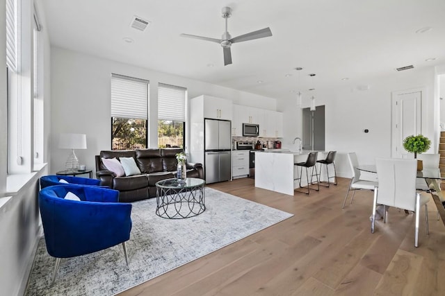 living area featuring ceiling fan, wood finished floors, and recessed lighting