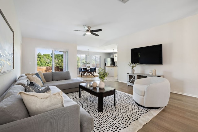 living room with ceiling fan, wood finished floors, and baseboards