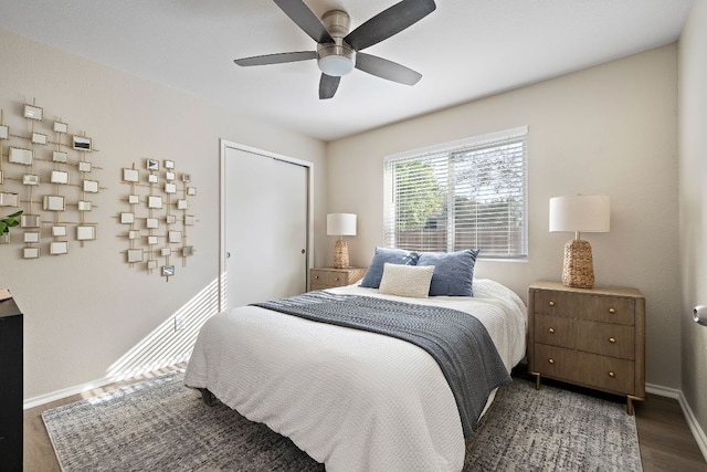bedroom featuring baseboards, wood finished floors, a closet, and ceiling fan