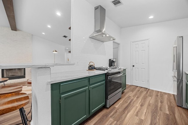 kitchen featuring green cabinets, stainless steel appliances, island exhaust hood, light wood-style floors, and beamed ceiling
