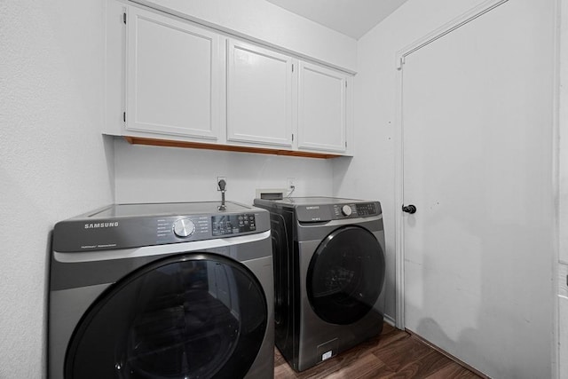 laundry room with cabinet space, washer and dryer, and dark wood-style flooring